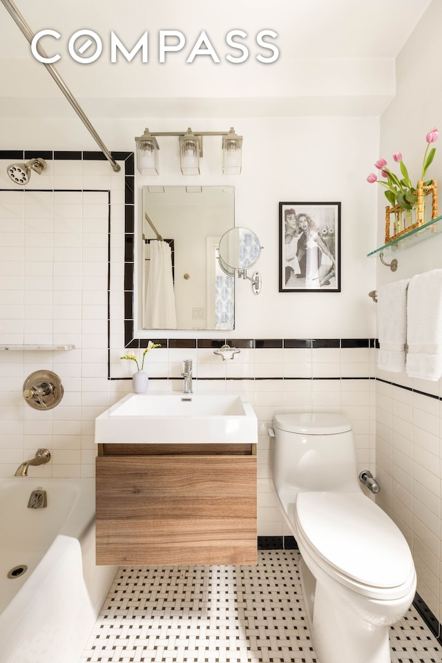 200 E 16th St Unit 14C, New York City, NY 10003 - full bathroom with tile walls, vanity, toilet, shower / tub combo with curtain, and tile patterned floors