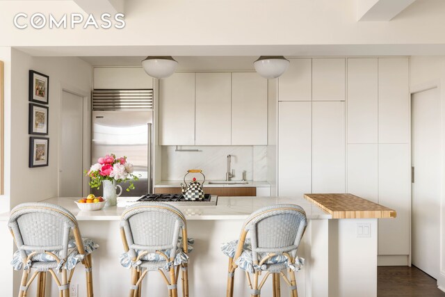 200 E 16th St Unit 14C, New York City, NY 10003 - kitchen with a sink, appliances with stainless steel finishes, a kitchen breakfast bar, light countertops, and modern cabinets