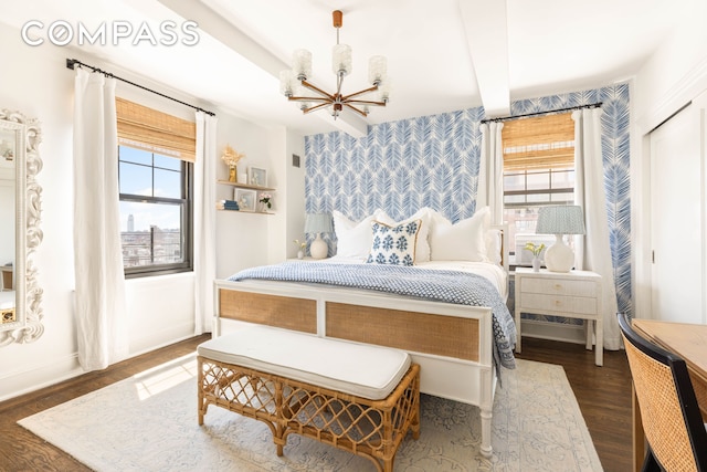 200 E 16th St Unit 14C, New York City, NY 10003 - bedroom featuring wallpapered walls, a chandelier, multiple windows, wood finished floors, and an accent wall