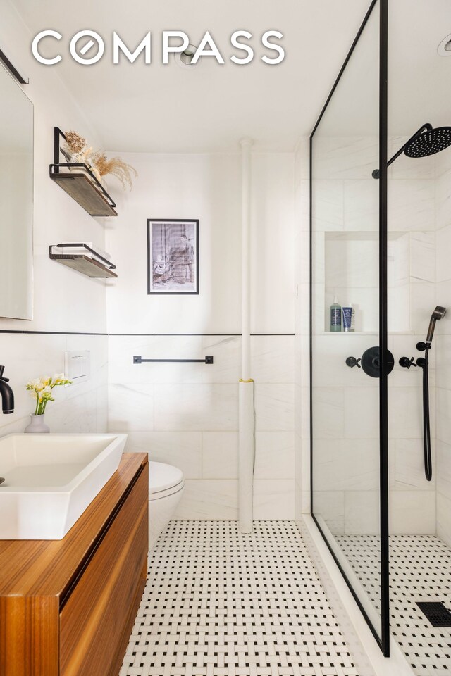 200 E 16th St Unit 14C, New York City, NY 10003 - full bathroom with a shower stall, vanity, toilet, tile walls, and tile patterned floors
