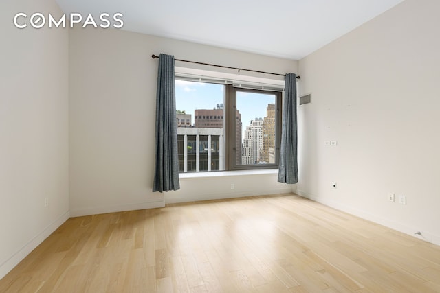 75 Wall St Unit 27F, New York City, NY 10005 - unfurnished room with wood finished floors and baseboards