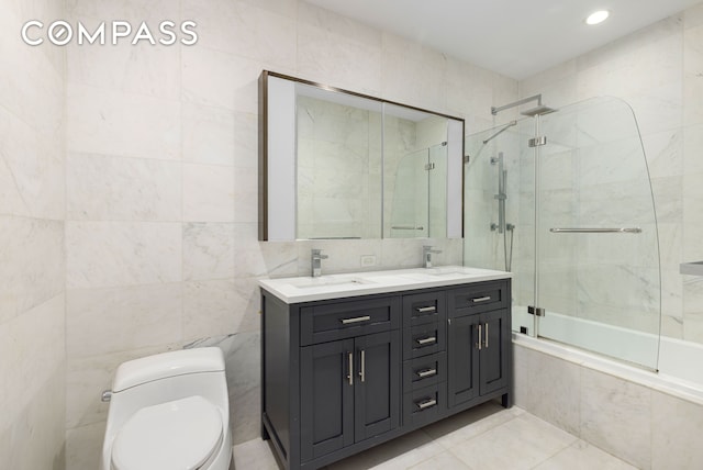75 Wall St Unit 27F, New York City, NY 10005 - full bathroom featuring tile walls, toilet, double vanity, tiled shower / bath combo, and tile patterned flooring