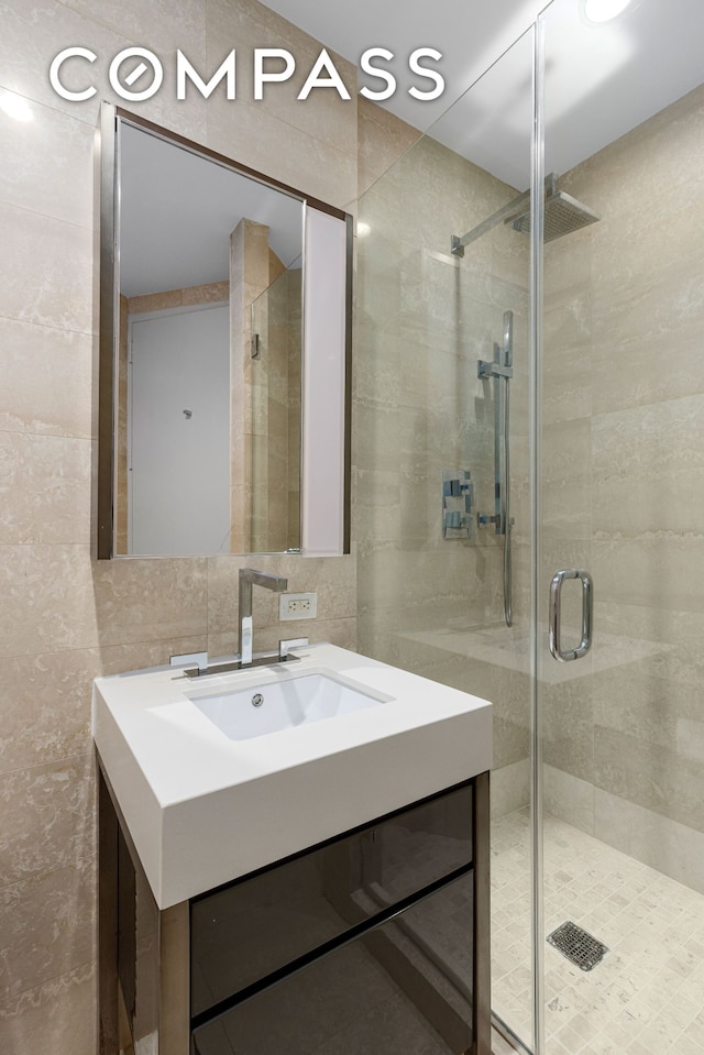 75 Wall St Unit 27F, New York City, NY 10005 - full bathroom with tile walls, a stall shower, and vanity