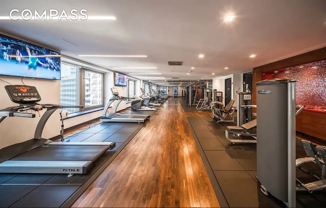 75 Wall St Unit 27F, New York City, NY 10005 - gym with hardwood / wood-style floors and recessed lighting