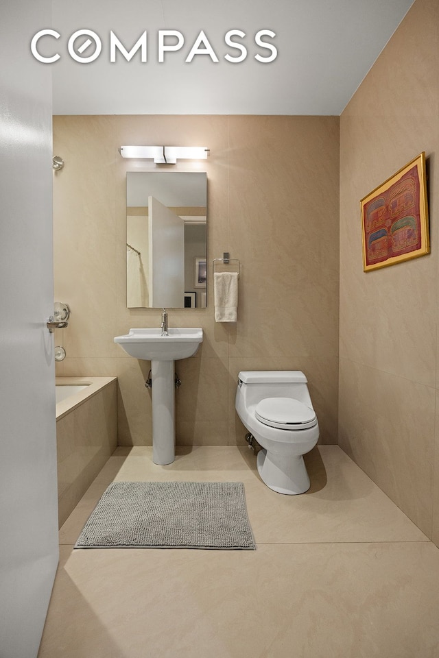 42 Ann St Unit 7, New York City, NY 10038 - full bath with tile patterned floors, toilet, a bathtub, and tile walls
