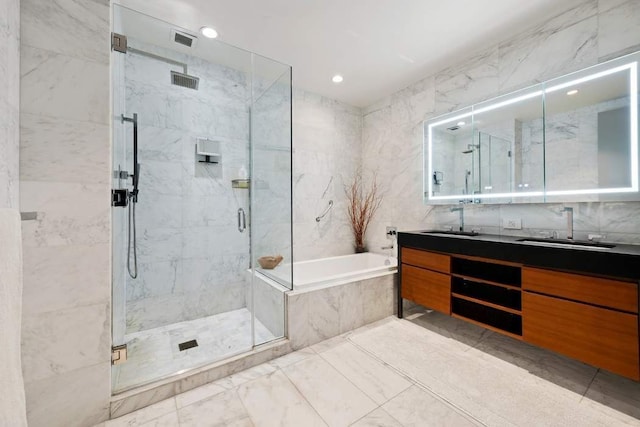 75 Wall St Unit 21N/O, New York City, NY 10005 - bathroom featuring a garden tub, double vanity, a marble finish shower, tile walls, and recessed lighting