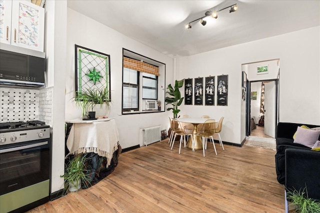 157 W 123rd St Unit 4C, New York City, NY 10027 - dining room with radiator heating unit, light wood finished floors, track lighting, and cooling unit