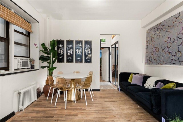 157 W 123rd St Unit 4C, New York City, NY 10027 - dining space featuring radiator heating unit, wood finished floors, and cooling unit