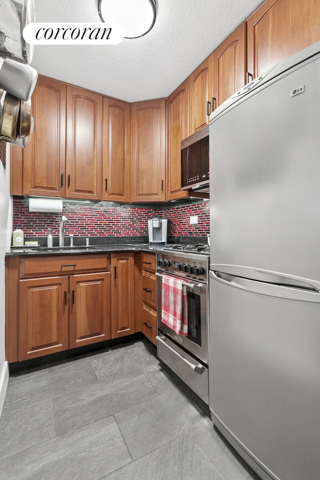 520 E 81st St Unit 8A, New York City, NY 10028 - kitchen featuring appliances with stainless steel finishes, dark countertops, backsplash, and a textured ceiling