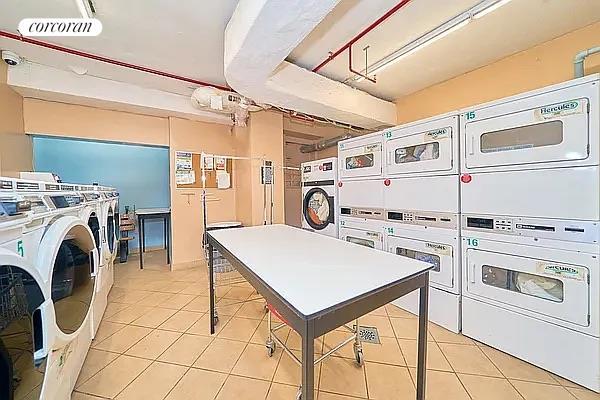 520 E 81st St Unit 8A, New York City, NY 10028 - community laundry featuring stacked washer / dryer, light tile patterned floors, and independent washer and dryer