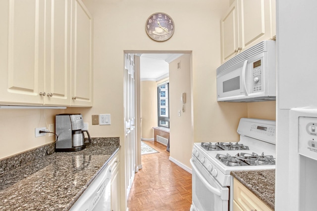 167 E 61st St Unit 11B, New York City, NY 10065 - kitchen with white appliances, dark stone countertops, baseboards, and crown molding