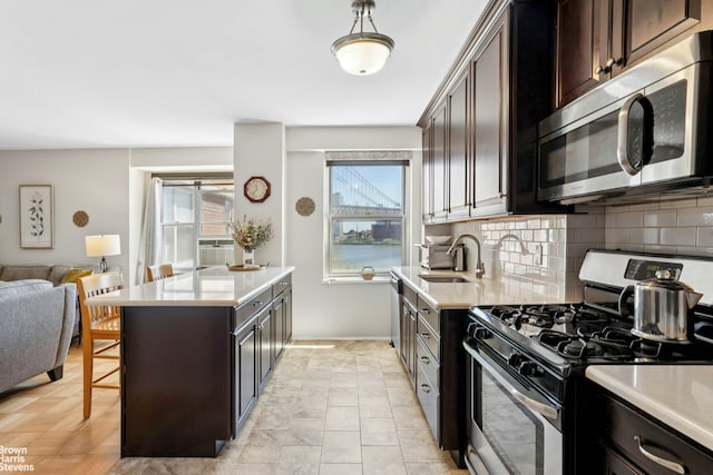 473 Fdr Dr Unit K801, New York City, NY 10002 - kitchen with stainless steel appliances, light countertops, a breakfast bar area, and open floor plan