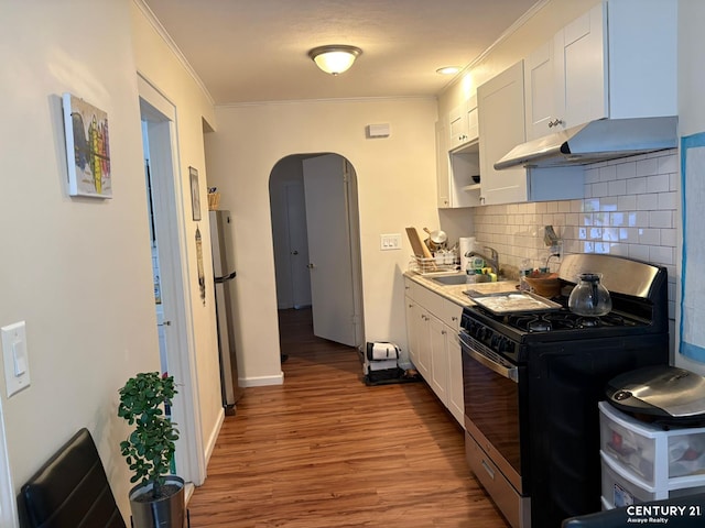 2032 W 4th St, New York City, NY 11223 - kitchen with appliances with stainless steel finishes, a sink, arched walkways, crown molding, and white cabinets