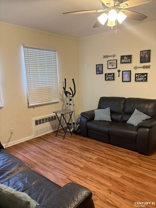 2032 W 4th St, New York City, NY 11223 - living area with crown molding, wood finished floors, radiator heating unit, a ceiling fan, and baseboards