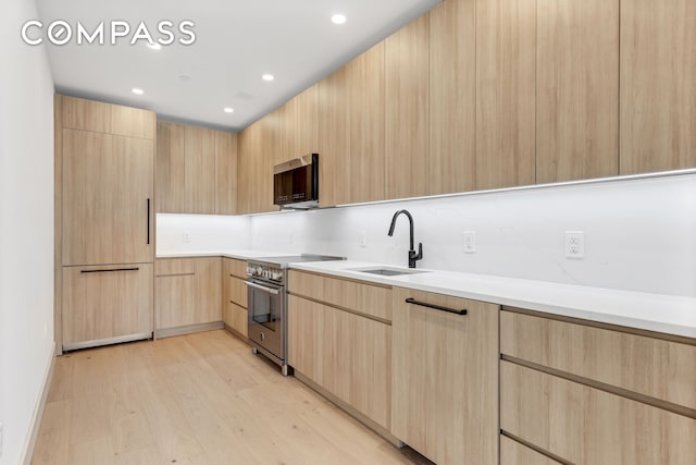 12-16 30th Ave Unit 305, New York City, NY 11102 - kitchen with light brown cabinets, appliances with stainless steel finishes, a sink, modern cabinets, and light countertops