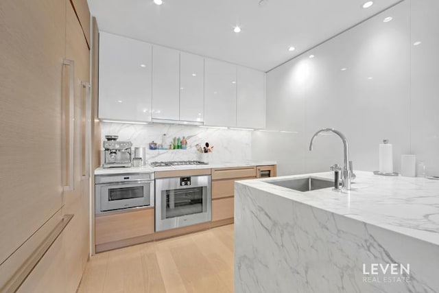 30 Riverside Blvd Unit 22F, New York City, NY 10069 - kitchen with modern cabinets, appliances with stainless steel finishes, white cabinets, light stone counters, and backsplash