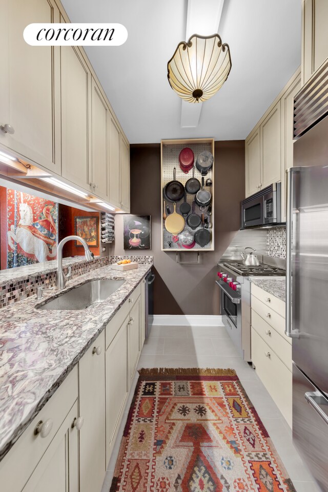 400 E 90th St Unit 8F, New York City, NY 10128 - kitchen featuring a sink, high end appliances, backsplash, baseboards, and light tile patterned flooring