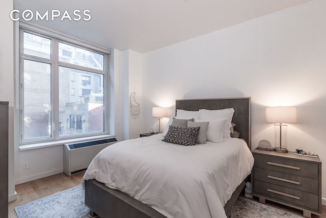 325 5th Ave Unit 14E, New York City, NY 10016 - bedroom with radiator heating unit, light wood finished floors, and baseboards