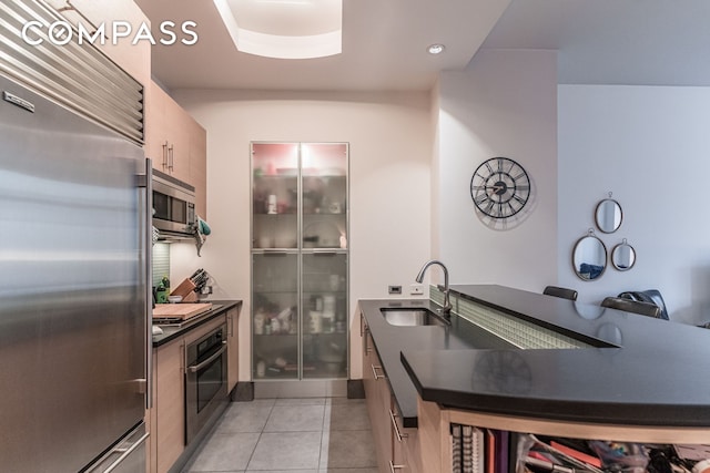 325 5th Ave Unit 14E, New York City, NY 10016 - kitchen with stainless steel appliances, a sink, dark countertops, light tile patterned floors, and modern cabinets