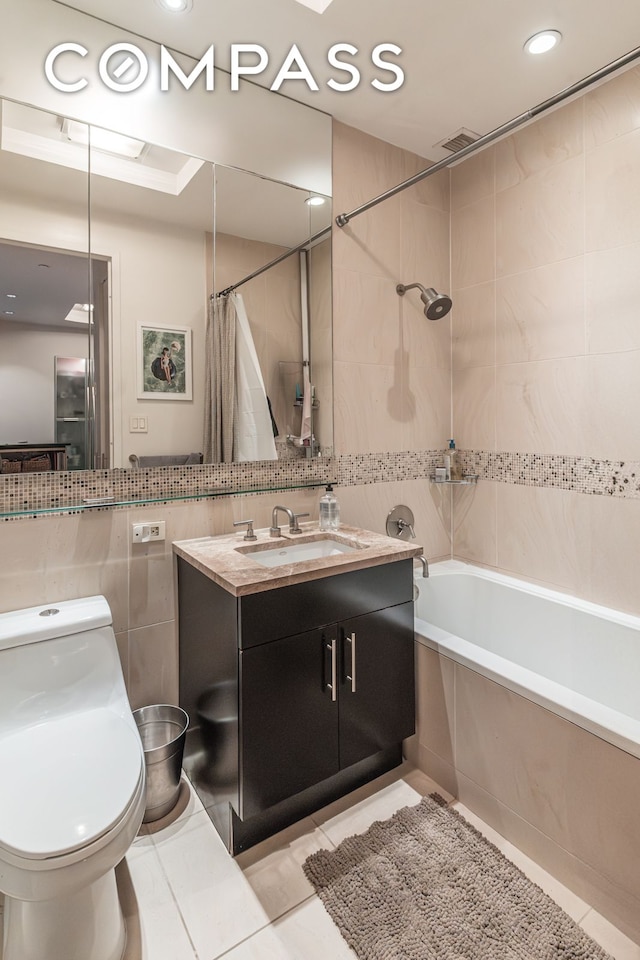 325 5th Ave Unit 14E, New York City, NY 10016 - bathroom featuring tile walls, shower / bath combination with curtain, vanity, toilet, and tile patterned flooring