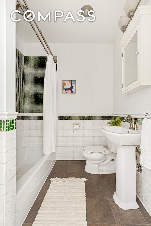 203 Lefferts Ave, New York City, NY 11225 - bathroom with tile walls, tile patterned floors, shower / bath combo with shower curtain, and a wainscoted wall