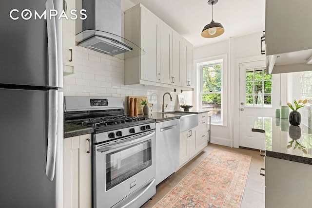 203 Lefferts Ave, New York City, NY 11225 - kitchen featuring appliances with stainless steel finishes, wall chimney range hood, dark countertops, white cabinets, and backsplash