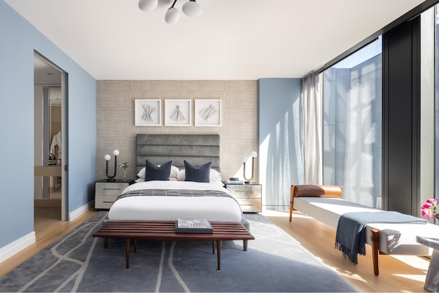 53 W 53rd St Unit 33B, New York City, NY 10019 - bedroom with an accent wall, wood finished floors, and baseboards