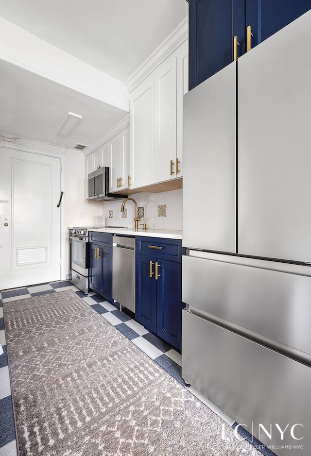 310 Riverside Dr Unit 1804, New York City, NY 10025 - kitchen featuring stainless steel appliances, blue cabinetry, white cabinets, light floors, and a sink