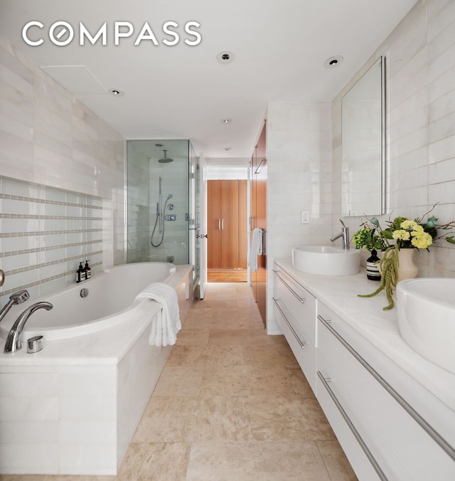 16 Warren St Unit 5, New York City, NY 10007 - bathroom featuring tile walls, a stall shower, double vanity, and a bath