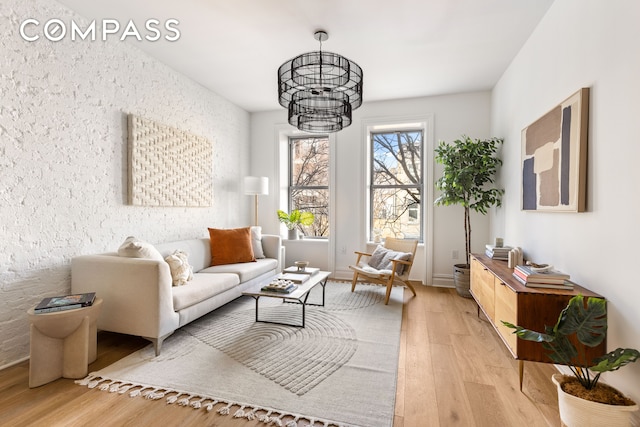 744 Park Pl Unit 1A, New York City, NY 11216 - living area featuring light wood-style flooring and a chandelier