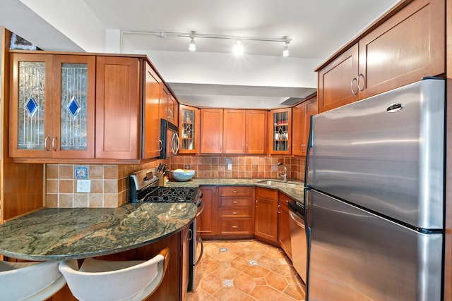 111 Hicks St Unit 5-Qr, New York City, NY 11201 - kitchen with stainless steel appliances, brown cabinetry, dark stone counters, and glass insert cabinets