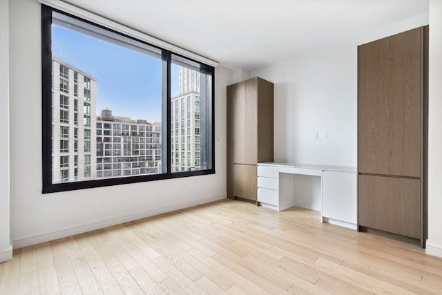 45-30 Pearson St Unit 6F, New York City, NY 11101 - unfurnished room with light wood-style floors, baseboards, and a view of city