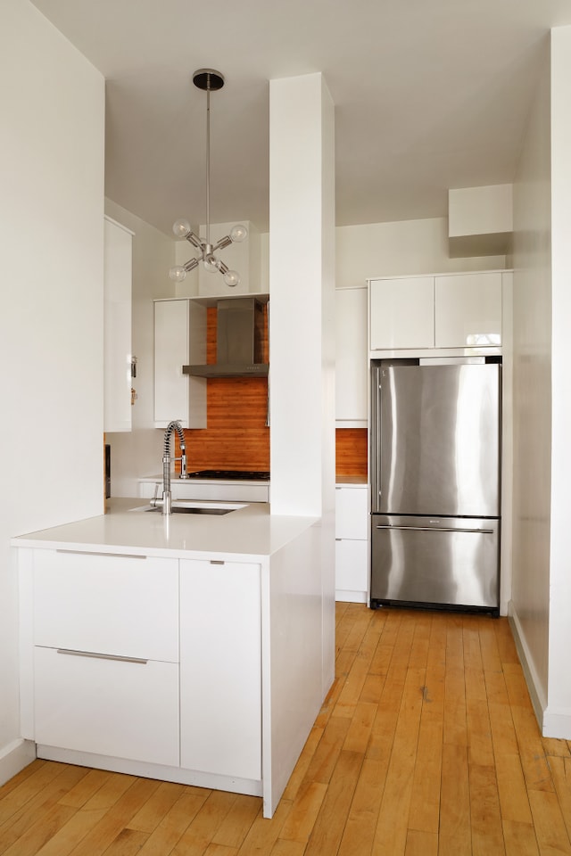 136 Powers St Unit 1G, New York City, NY 11211 - kitchen featuring freestanding refrigerator, modern cabinets, a sink, a chandelier, and white cabinetry