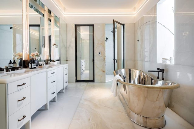 111 W 57th St Unit 57, New York City, NY 10019 - bathroom with double vanity, a shower stall, a freestanding bath, and marble finish floors