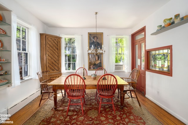 422 W 46th St Unit 2R, New York City, NY 10036 - dining area featuring a baseboard heating unit, healthy amount of natural light, and wood finished floors