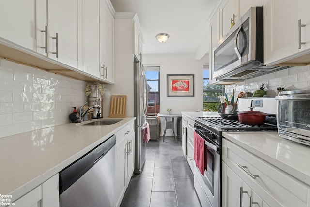61-09 39th Ave Unit N4, New York City, NY 11377 - kitchen with stainless steel appliances, tasteful backsplash, a sink, and white cabinets