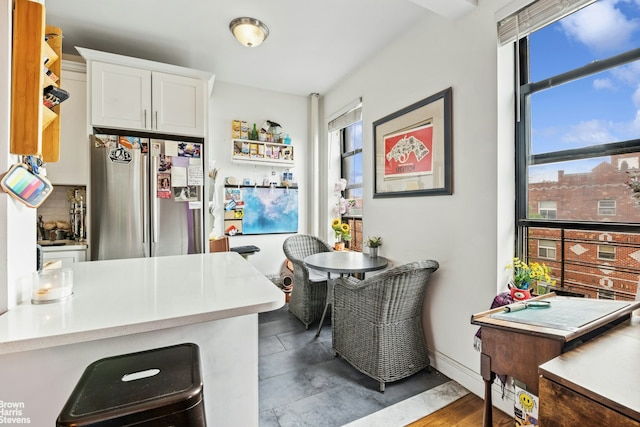 61-09 39th Ave Unit N4, New York City, NY 11377 - kitchen featuring freestanding refrigerator, white cabinets, light countertops, and baseboards