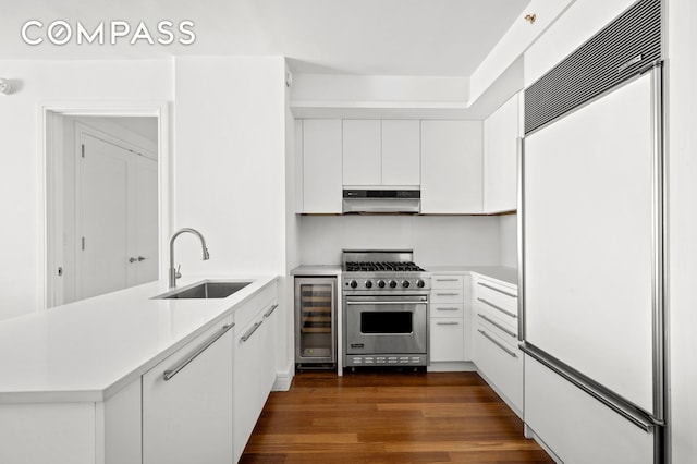 30 W St Unit 25G, New York City, NY 10004 - kitchen with high quality appliances, a sink, wine cooler, range hood, and a peninsula
