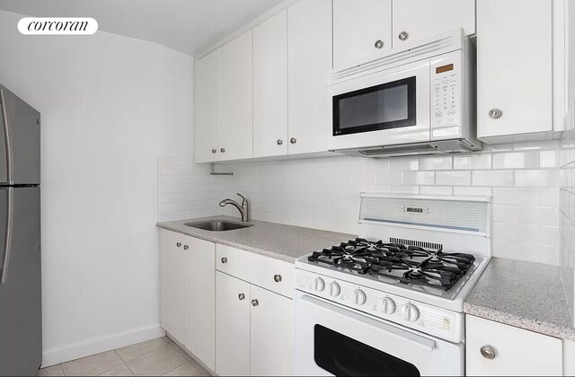 67 E 11th St Unit 620, New York City, NY 10003 - kitchen with white appliances, a sink, white cabinets, and tasteful backsplash