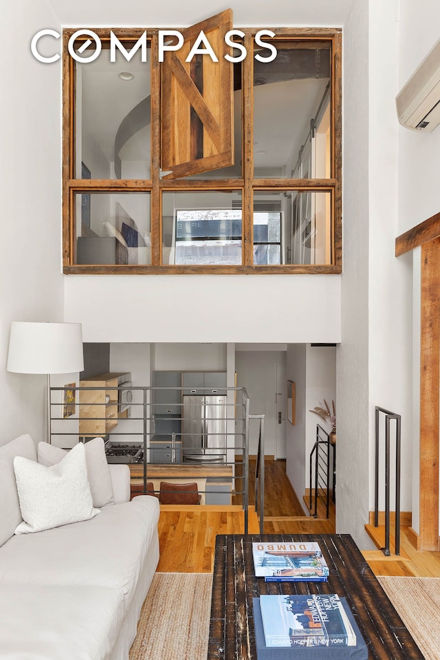37 Bridge St Unit 1F, New York City, NY 11201 - living room featuring a wall unit AC and wood finished floors