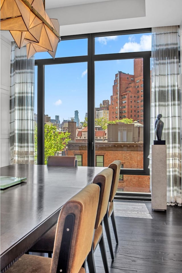 155 W 11th St Unit 4G, New York City, NY 10011 - dining room featuring a skyline view, wood finished floors, and a wall of windows