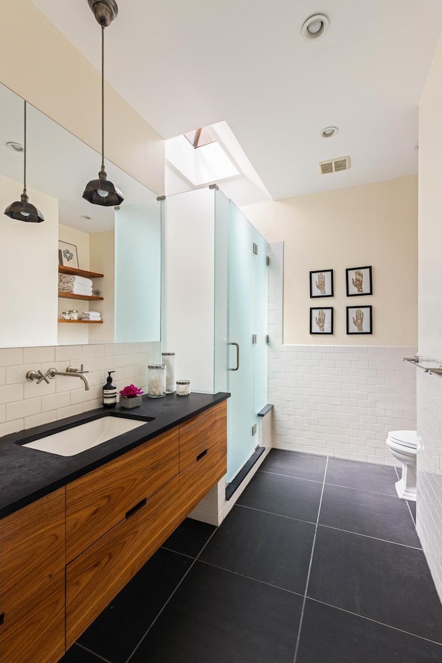 208 Garfield Place, New York City, NY 11215 - full bath with tile patterned flooring, a shower stall, a skylight, vanity, and tile walls