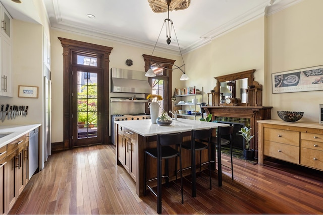 208 Garfield Place, New York City, NY 11215 - kitchen featuring wall chimney exhaust hood, dark wood-type flooring, a breakfast bar, a kitchen island, and crown molding