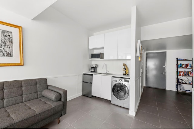 214 N 11th St Unit 1X, New York City, NY 11211 - kitchen with washer / clothes dryer, fridge, stainless steel microwave, dark tile patterned flooring, and white cabinetry
