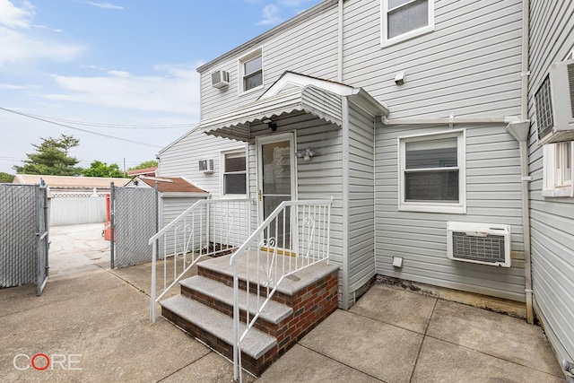 3707 Quentin Rd, New York City, NY 11234 - view of exterior entry featuring a wall mounted air conditioner, a patio, and cooling unit