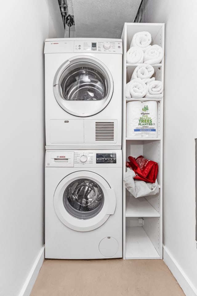 500 4th Ave Unit 5F, New York City, NY 11215 - washroom with stacked washer / drying machine, baseboards, and carpet floors