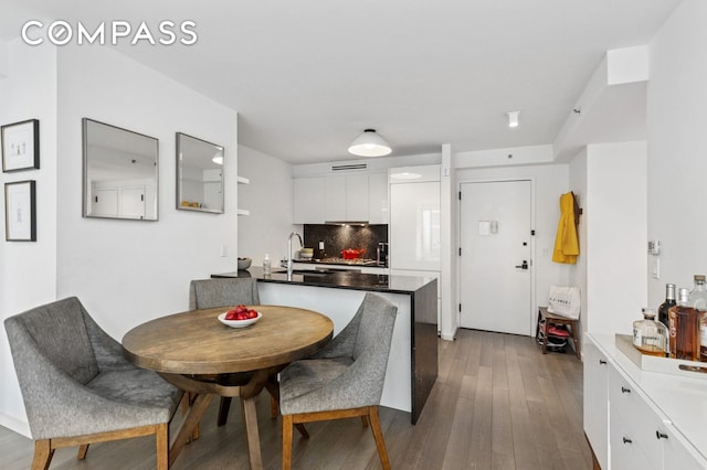 385 1st Ave Unit 6B, New York City, NY 10010 - kitchen with white cabinets, modern cabinets, decorative backsplash, and wood finished floors