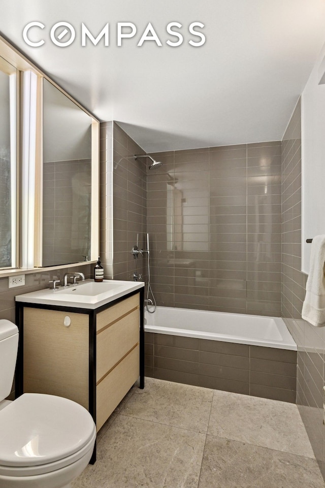 385 1st Ave Unit 6B, New York City, NY 10010 - bathroom with tiled shower / bath, vanity, tile patterned flooring, and tile walls