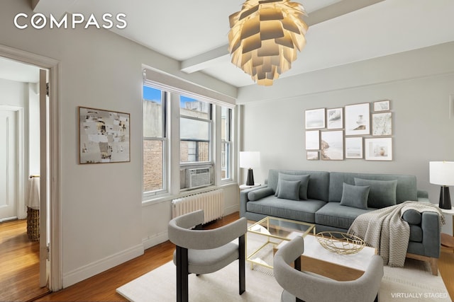 325 W 45th St Unit 700, New York City, NY 10036 - living area featuring radiator heating unit, light wood-type flooring, cooling unit, and beam ceiling