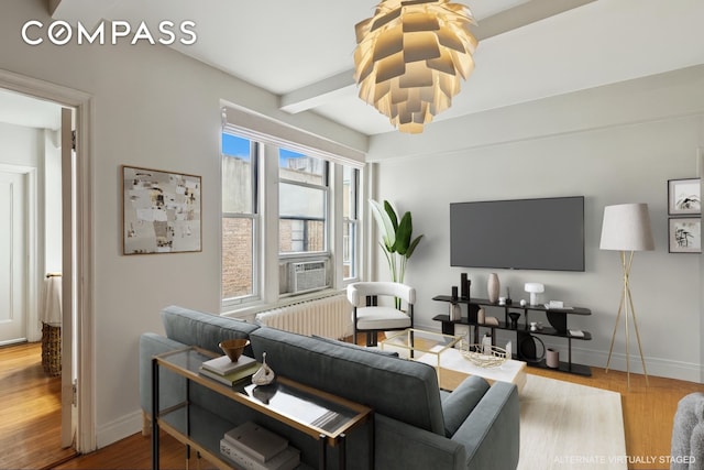 325 W 45th St Unit 700, New York City, NY 10036 - living room featuring wood finished floors, cooling unit, radiator, and beamed ceiling